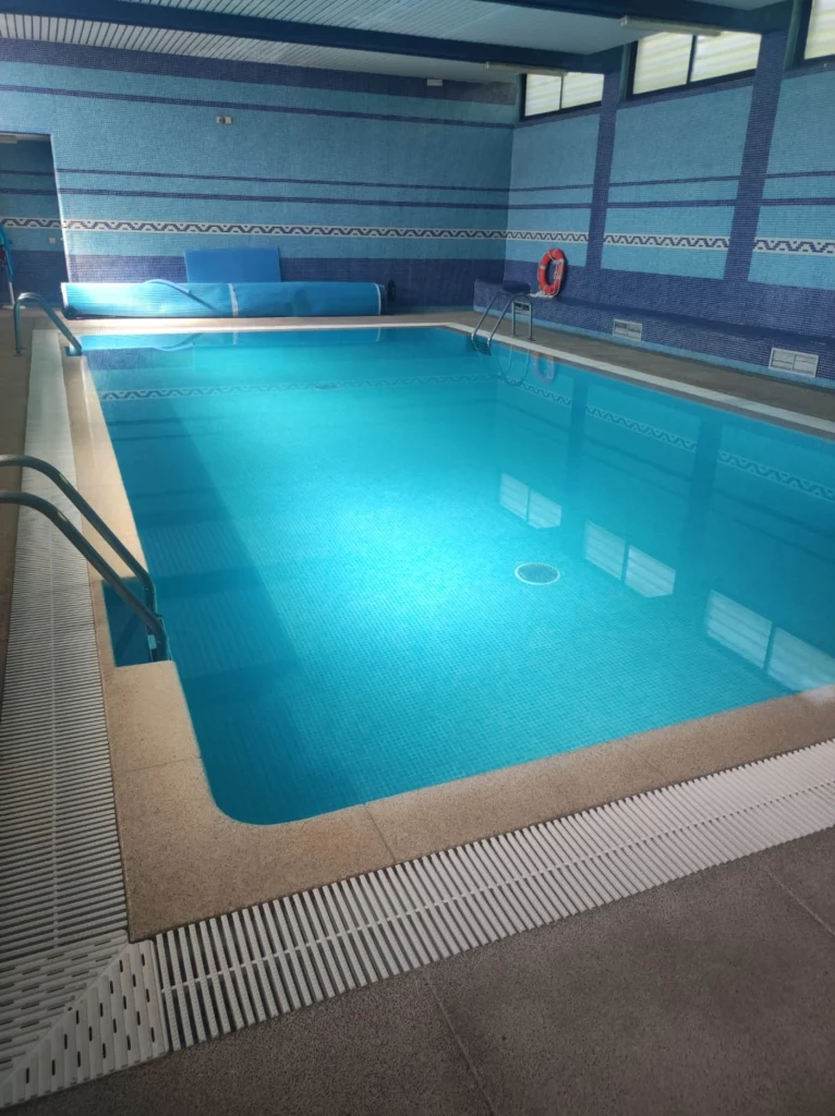Piscina cubierta con agua cristalina tras mantenimiento profesional en Madrid