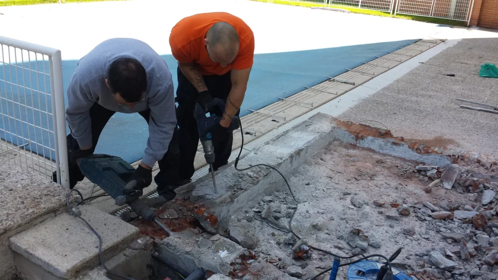 Técnicos realizando trabajos de reparación en una piscina durante el mantenimiento de piscinas en Madrid
